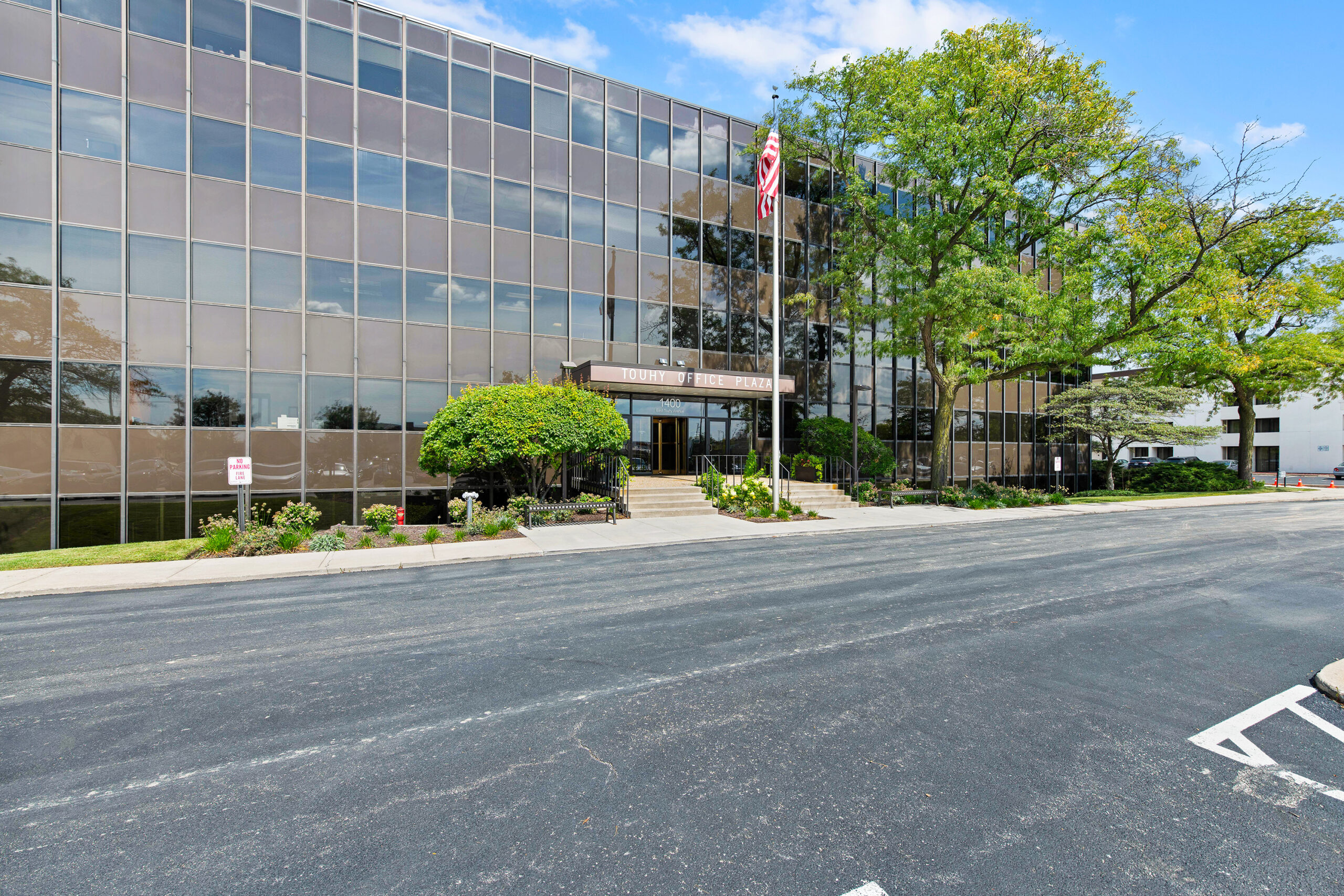 Exterior view of 1400 E. Touhy Ave., Des Plaines, IL 60018, a modern office building with large windows and landscaped surroundings.