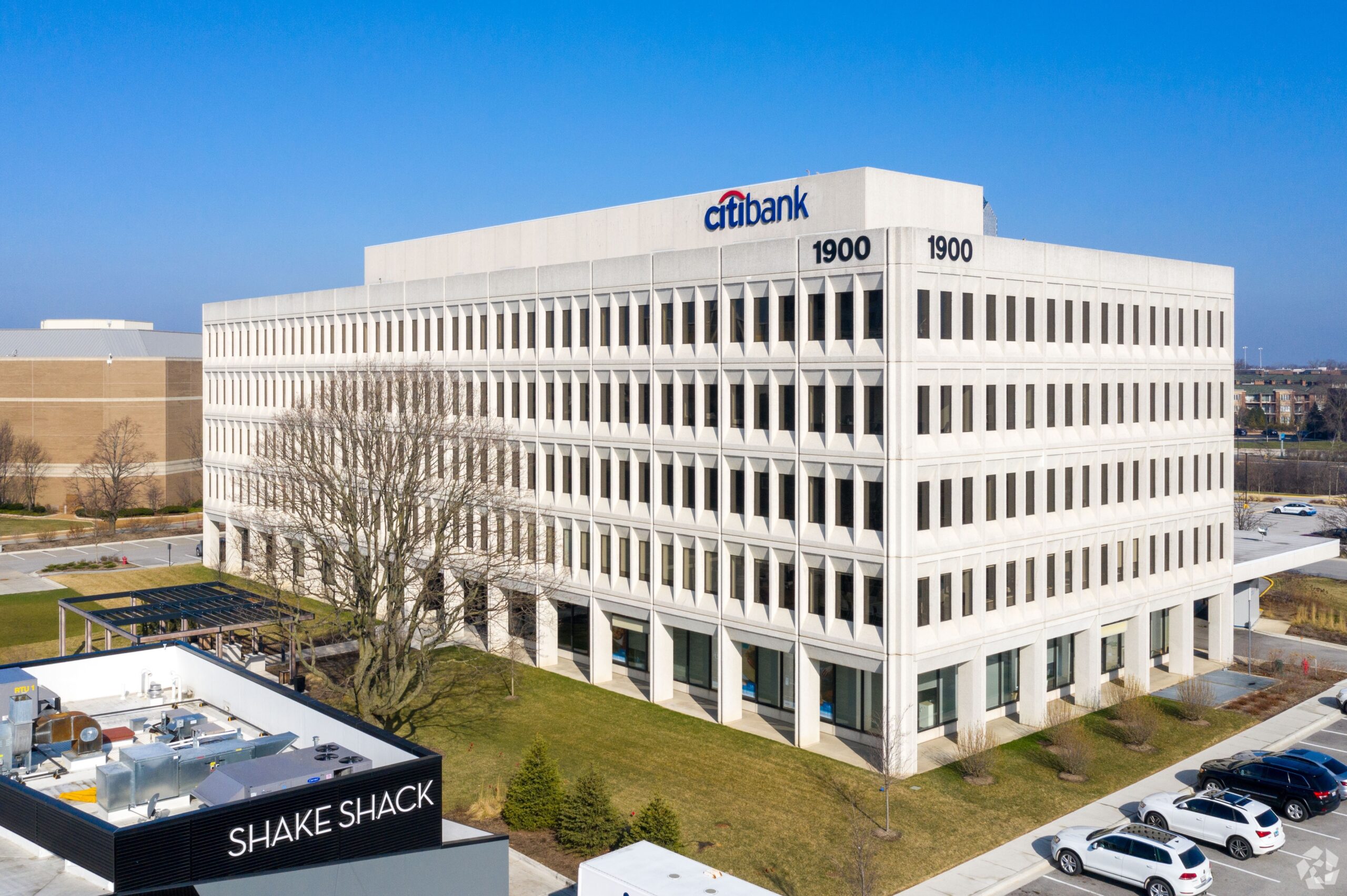 Exterior view of 1900 Spring Rd., Oak Brook, IL 60523, a five-story office building with modern architecture and landscaped surroundings.
